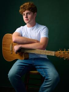 Senior Portraits of a young red haired man with a guitar